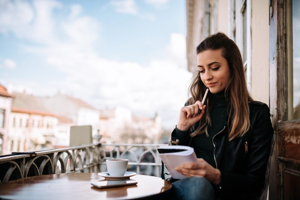 young pensive female writter sitting terrace