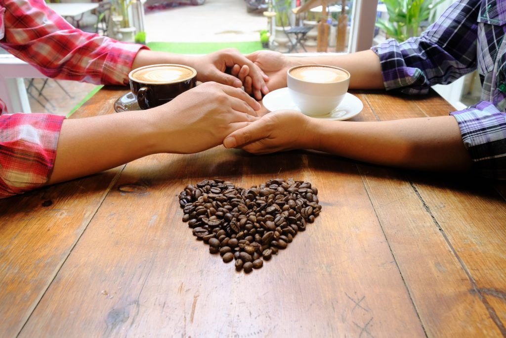 couple love holding hands with coffee wooden table